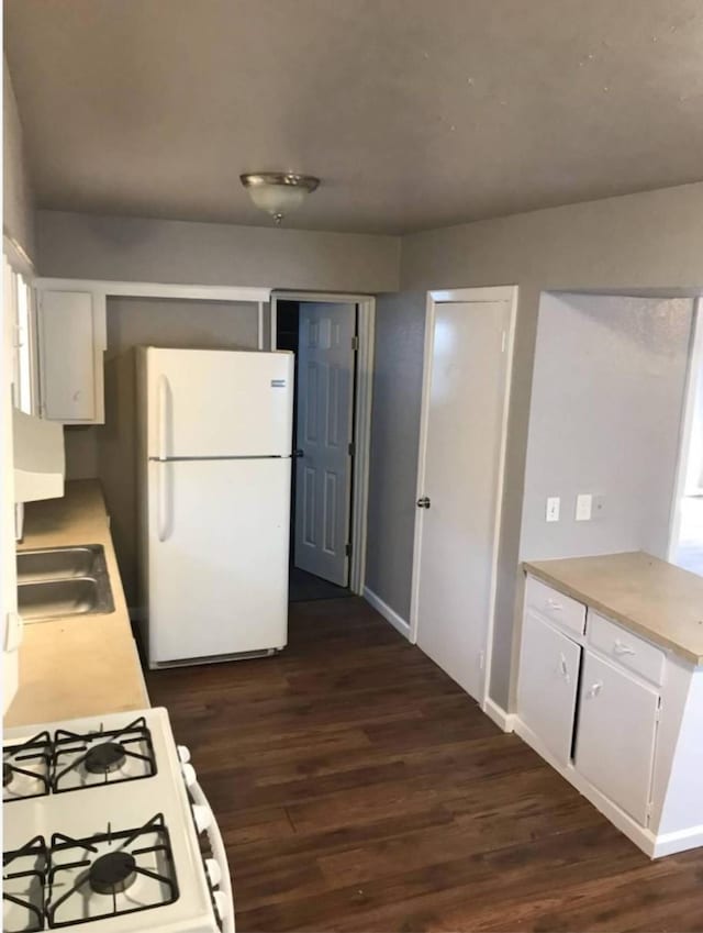 511 W Cleveland St, Alvin, TX 77511 - kitchen featuring white appliances, a sink, dark wood-type flooring, and white cabinets