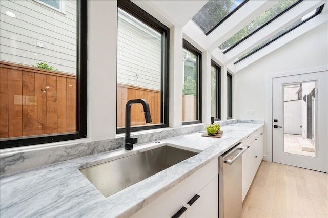 2135 Quenby St, Houston, TX 77005 - kitchen with a sink, light stone counters, white cabinetry, lofted ceiling, and dishwasher