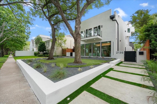 2135 Quenby St, Houston, TX 77005 - rear view of house with a balcony, a gate, and stucco siding