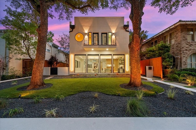 2135 Quenby St, Houston, TX 77005 - back of property at dusk featuring a yard and stucco siding