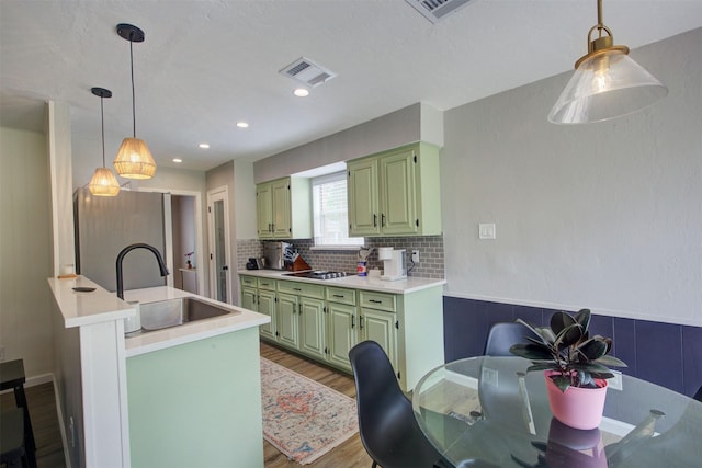 6019 Lawn Ln, Houston, TX 77088 - kitchen with green cabinets, freestanding refrigerator, wood finished floors, light countertops, and recessed lighting