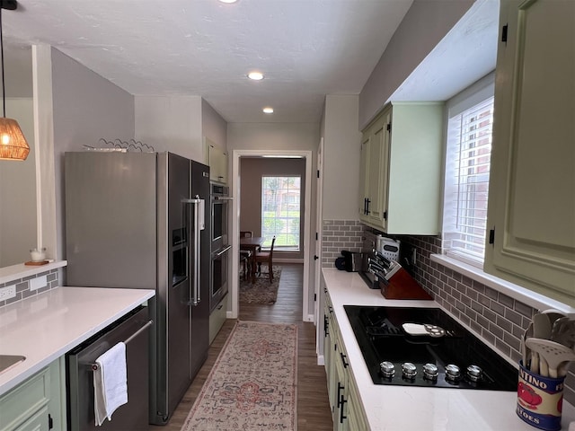 6019 Lawn Ln, Houston, TX 77088 - kitchen featuring appliances with stainless steel finishes, green cabinetry, light countertops, decorative backsplash, and recessed lighting