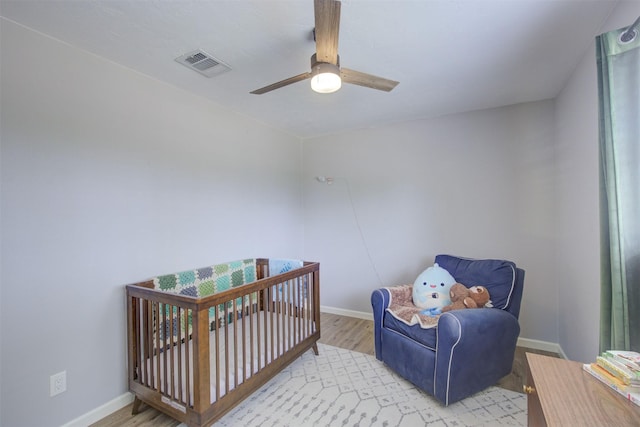 6019 Lawn Ln, Houston, TX 77088 - bedroom with wood finished floors, a nursery area, and ceiling fan