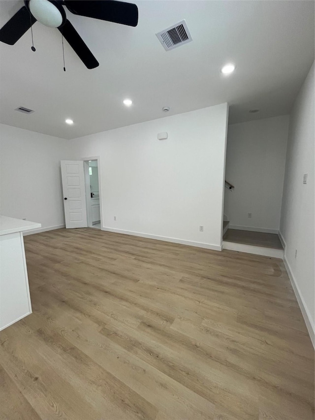 8605 Wileyvale Rd, Houston, TX 77016 - unfurnished living room with a ceiling fan, stairs, light wood-type flooring, baseboards, and recessed lighting