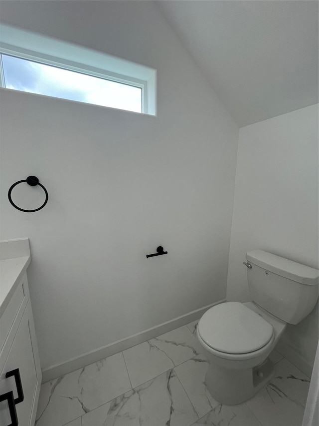 8605 Wileyvale Rd, Houston, TX 77016 - bathroom with marble look tiles, vanity, toilet, and baseboards