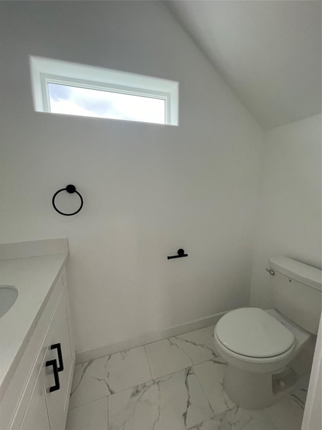 8605 Wileyvale Rd, Houston, TX 77016 - bathroom with vanity, marble finish floors, toilet, lofted ceiling, and baseboards