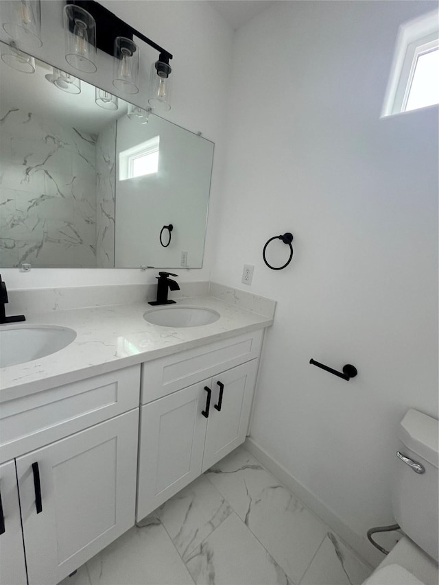 8605 Wileyvale Rd, Houston, TX 77016 - full bathroom featuring double vanity, toilet, marble finish floors, and plenty of natural light