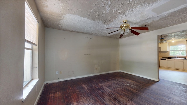 4618 Mallow St, Houston, TX 77051 - empty room with hardwood / wood-style flooring, a ceiling fan, a sink, a textured ceiling, and baseboards