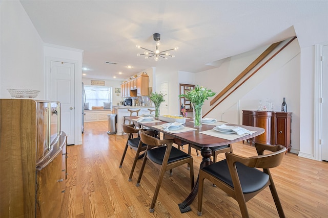 3663 Nasa Pkwy Unit 601, Seabrook, TX 77586 - dining room featuring light wood-style floors, a chandelier, and stairway