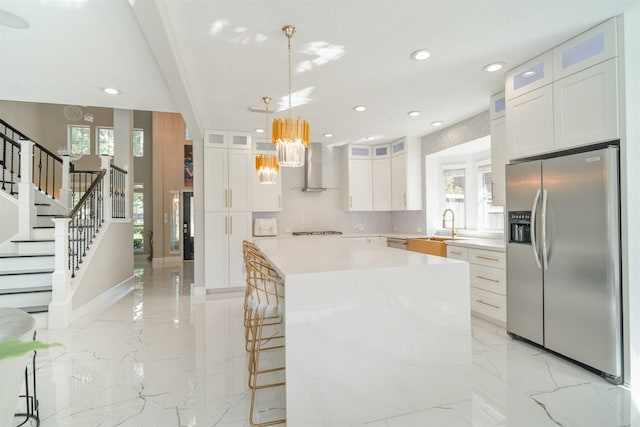 5515 E Terrace Gable Cir, Katy, TX 77494 - kitchen featuring stainless steel refrigerator with ice dispenser, a chandelier, wall chimney range hood, healthy amount of natural light, and recessed lighting