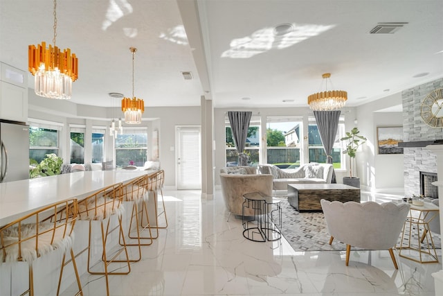 5515 E Terrace Gable Cir, Katy, TX 77494 - living area with a chandelier, a fireplace, and light marble finish floors