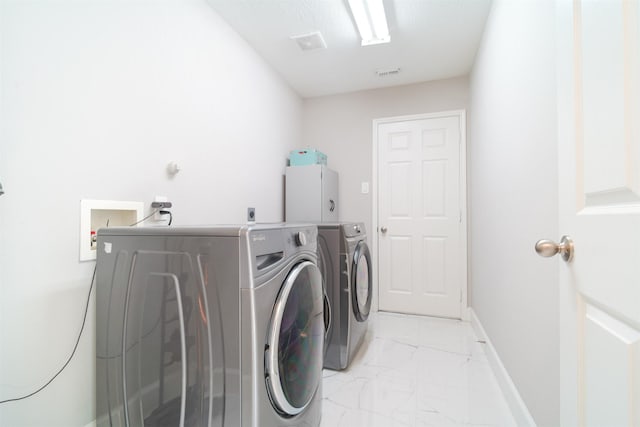 5515 E Terrace Gable Cir, Katy, TX 77494 - laundry room with light marble finish floors, washing machine and dryer, and baseboards