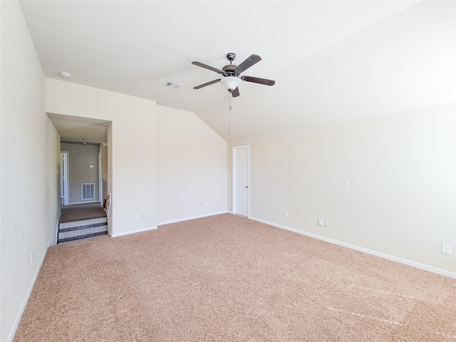 carpeted empty room with a ceiling fan, vaulted ceiling, baseboards, and a smoke detector