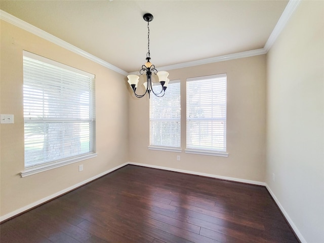 spare room with a chandelier, plenty of natural light, dark wood-style flooring, crown molding, and baseboards