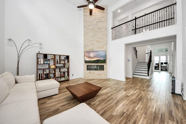17355 Camillia Trl, Conroe, TX 77302 - living area with a high ceiling, ceiling fan, wood finished floors, stairs, and a fireplace