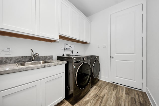 17355 Camillia Trl, Conroe, TX 77302 - washroom with separate washer and dryer, cabinet space, light wood-style flooring, and baseboards
