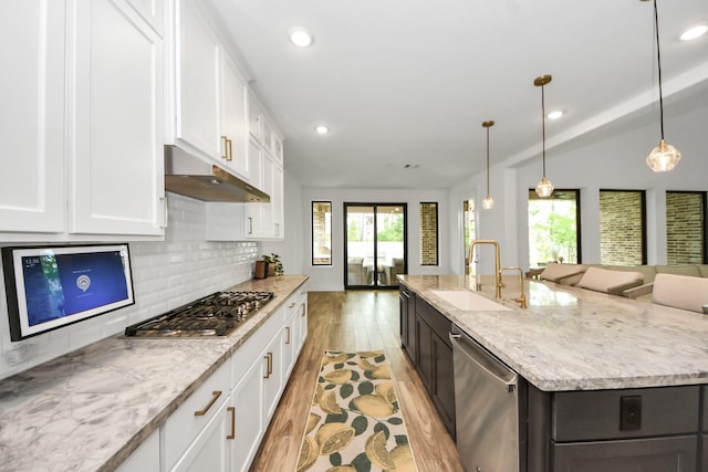 17355 Camillia Trl, Conroe, TX 77302 - kitchen with stainless steel appliances, a sink, under cabinet range hood, an island with sink, and healthy amount of natural light