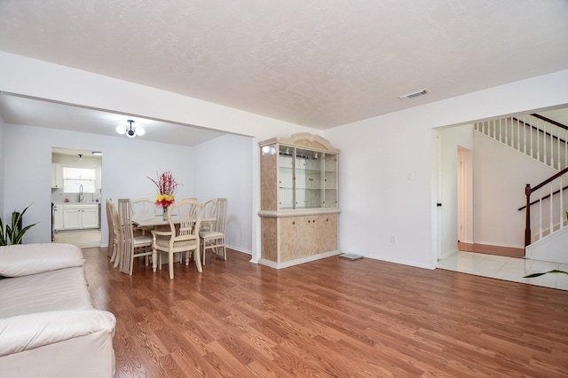 16023 Mission Glen Dr, Houston, TX 77083 - living area featuring stairway, light wood-type flooring, and baseboards