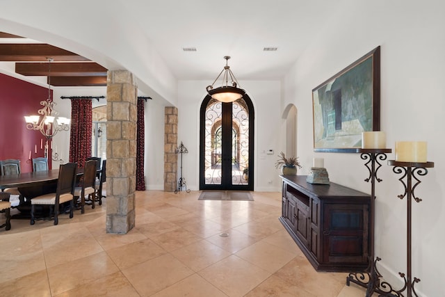 2602 Britton Ridge Dr, Katy, TX 77494 - entrance foyer with arched walkways, ornate columns, a chandelier, light tile patterned floors, and french doors