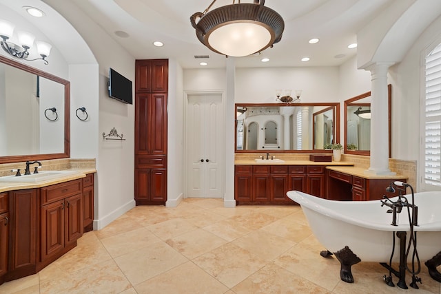 2602 Britton Ridge Dr, Katy, TX 77494 - bathroom featuring decorative columns, a freestanding bath, two vanities, recessed lighting, and tile patterned flooring