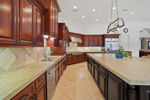 2602 Britton Ridge Dr, Katy, TX 77494 - kitchen with stainless steel appliances, a sink, light countertops, wall chimney range hood, and reddish brown cabinets