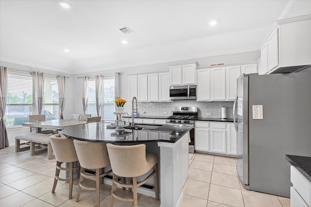1915 Hays Ranch Dr, Richmond, TX 77469 - kitchen featuring stainless steel appliances, a sink, light tile patterned flooring, a breakfast bar area, and ornamental molding