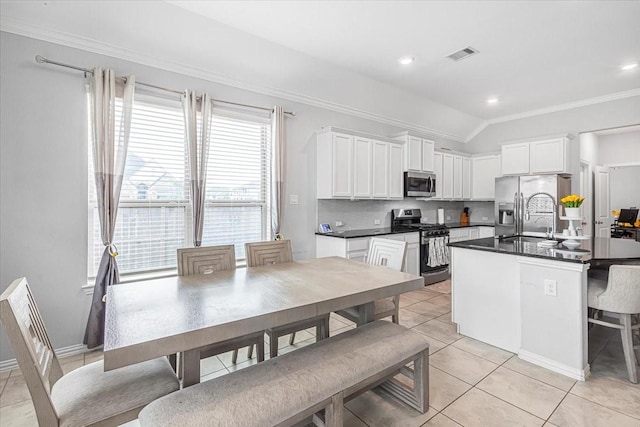 1915 Hays Ranch Dr, Richmond, TX 77469 - kitchen with stainless steel appliances, ornamental molding, dark countertops, a sink, and white cabinets