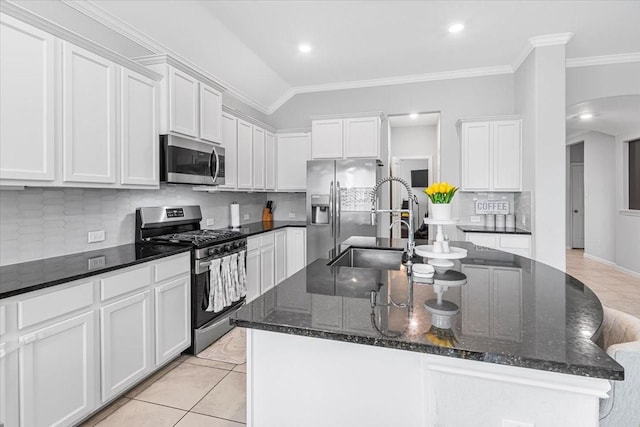 1915 Hays Ranch Dr, Richmond, TX 77469 - kitchen featuring appliances with stainless steel finishes, a sink, a center island with sink, backsplash, and arched walkways