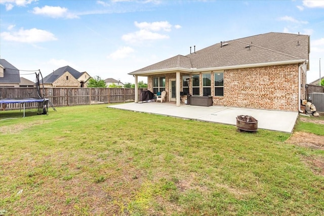 1915 Hays Ranch Dr, Richmond, TX 77469 - rear view of property featuring a patio, a trampoline, brick siding, and central air condition unit