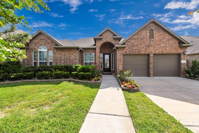 2003 Highland Meadows Dr, Pearland, TX 77089 - view of front facade with brick siding, an attached garage, a front lawn, driveway, and roof with shingles