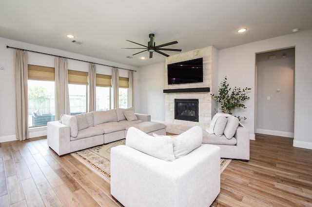 1907 Creekwood Cv, Missouri City, TX 77459 - living room featuring a ceiling fan, a fireplace, baseboards, light wood-style floors, and recessed lighting