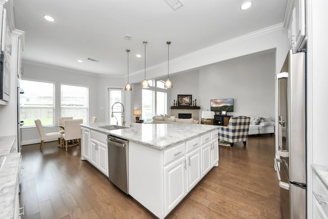 6510 Kangaroo Point Ln, Sugar Land, TX 77479 - kitchen featuring stainless steel appliances, a sink, crown molding, a center island with sink, and dark wood-type flooring