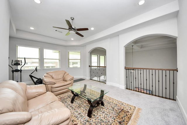 6510 Kangaroo Point Ln, Sugar Land, TX 77479 - carpeted living room featuring a ceiling fan, arched walkways, recessed lighting, baseboards, and a tray ceiling