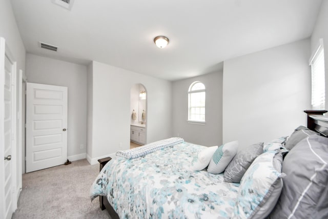 6510 Kangaroo Point Ln, Sugar Land, TX 77479 - bedroom with light colored carpet, arched walkways, baseboards, and ensuite bath