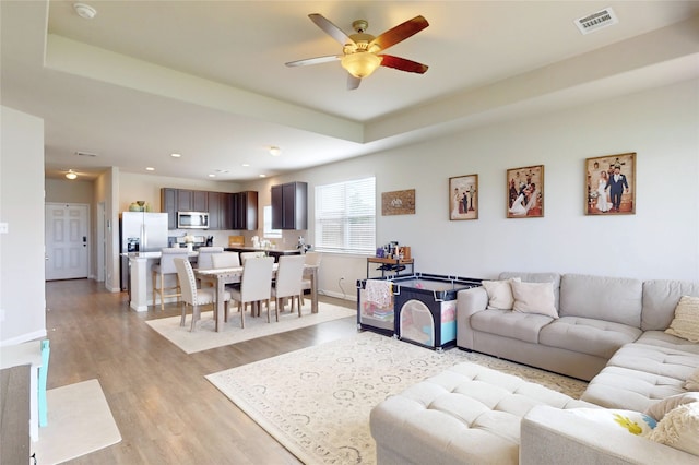 24803 Signorelli Way, Katy, TX 77493 - living room with ceiling fan, light wood finished floors, recessed lighting, baseboards, and a raised ceiling