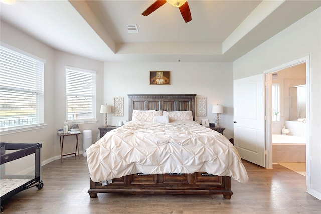 24803 Signorelli Way, Katy, TX 77493 - bedroom with a tray ceiling, wood finished floors, baseboards, ensuite bath, and a ceiling fan
