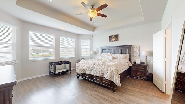 24803 Signorelli Way, Katy, TX 77493 - bedroom featuring a tray ceiling, light wood-type flooring, ceiling fan, and baseboards