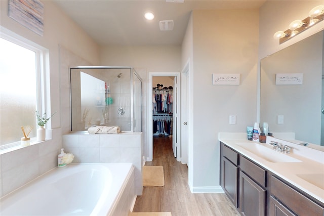 24803 Signorelli Way, Katy, TX 77493 - bathroom with a shower stall, wood finished floors, a bath, double vanity, and a walk in closet