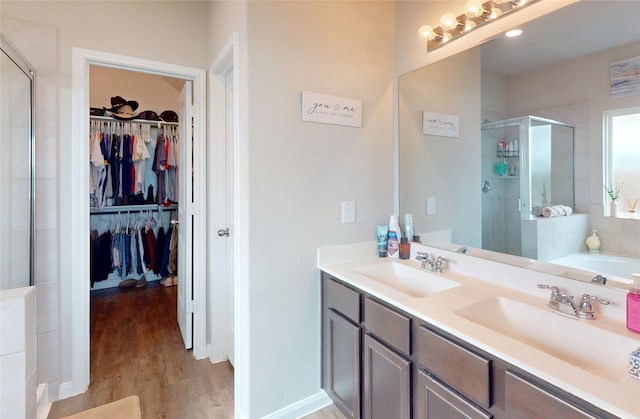 24803 Signorelli Way, Katy, TX 77493 - bathroom featuring a stall shower, a spacious closet, wood finished floors, and double vanity