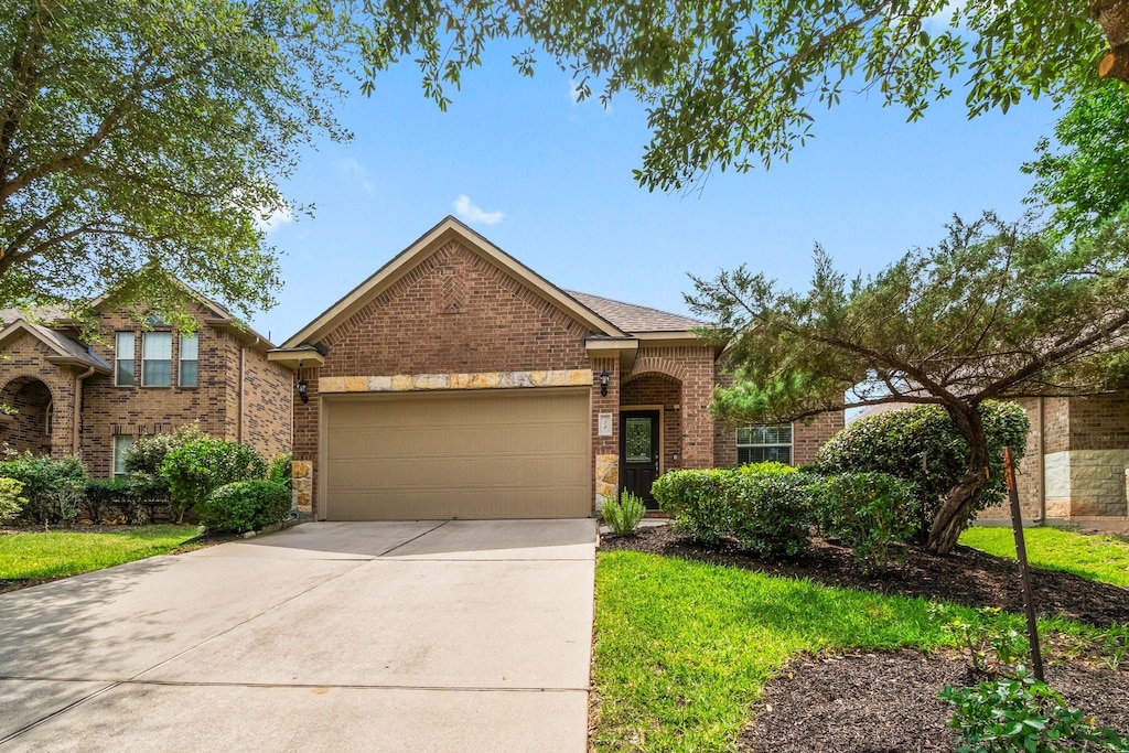 79 Black Swan Pl, The Woodlands, TX 77354 - traditional-style house with an attached garage, brick siding, and driveway