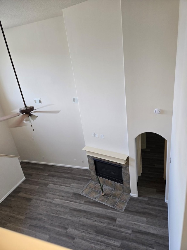 800 Mulligan Ct, Richmond, TX 77469 - detailed view of wood finished floors, a tiled fireplace, a ceiling fan, baseboards, and arched walkways