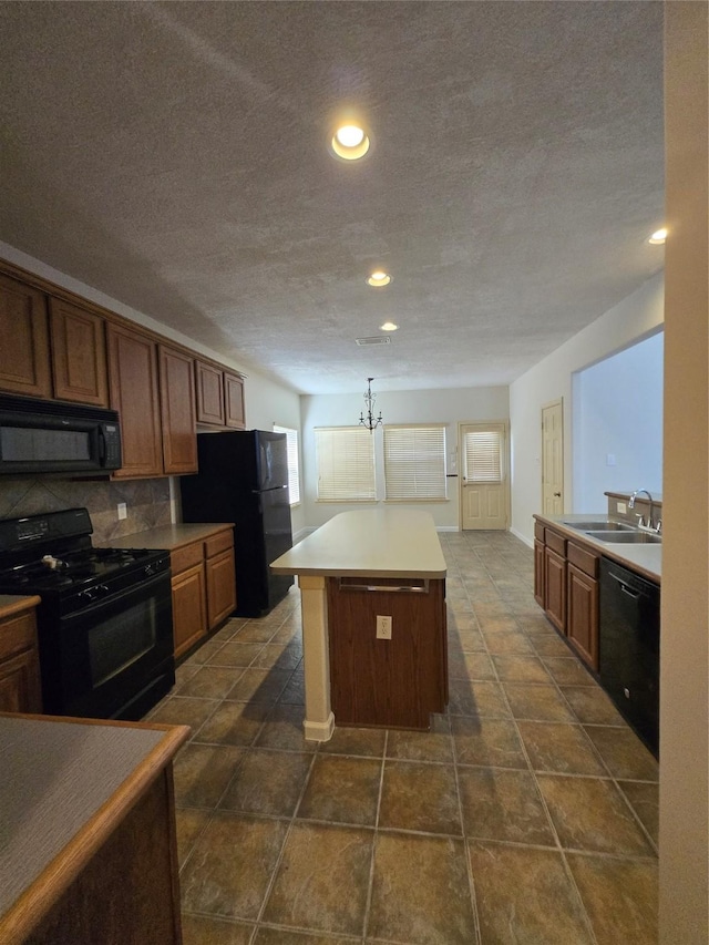 800 Mulligan Ct, Richmond, TX 77469 - kitchen with black appliances, a sink, decorative backsplash, a textured ceiling, and a kitchen island