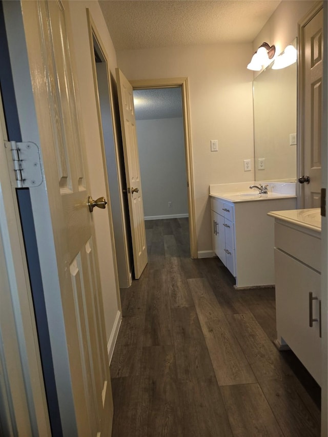800 Mulligan Ct, Richmond, TX 77469 - bathroom featuring vanity, wood finished floors, a textured ceiling, and baseboards