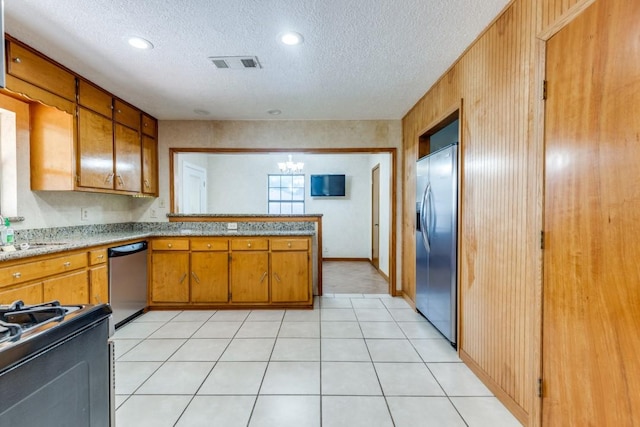 5718 Sheppard Rd, Baytown, TX 77521 - kitchen with appliances with stainless steel finishes, brown cabinetry, a textured ceiling, a sink, and a chandelier