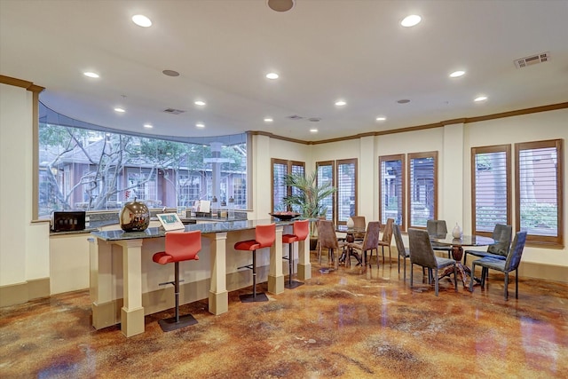2400 Mccue Rd Unit 230, Houston, TX 77056 - kitchen with recessed lighting, a breakfast bar area, crown molding, a spacious island, and finished concrete flooring