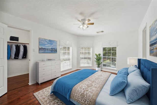 15026 Magnoliabough Pl, Cypress, TX 77429 - bedroom featuring dark wood-style flooring, a spacious closet, baseboards, a ceiling fan, and a closet