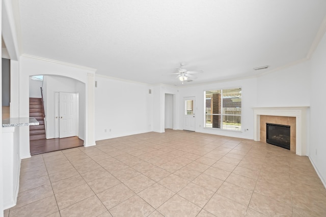 15026 Magnoliabough Pl, Cypress, TX 77429 - unfurnished living room with crown molding, a ceiling fan, stairway, a fireplace, and light tile patterned floors