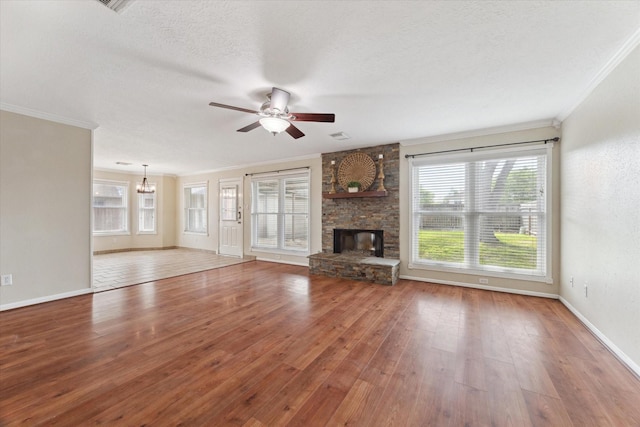 2709 Potomac Dr, League City, TX 77573 - unfurnished living room featuring crown molding, a ceiling fan, a stone fireplace, hardwood / wood-style flooring, and a chandelier
