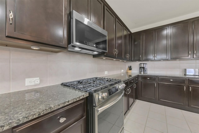 5335 Ivory Glass Dr, Katy, TX 77493 - kitchen with stainless steel appliances, dark stone counters, decorative backsplash, and light tile patterned flooring