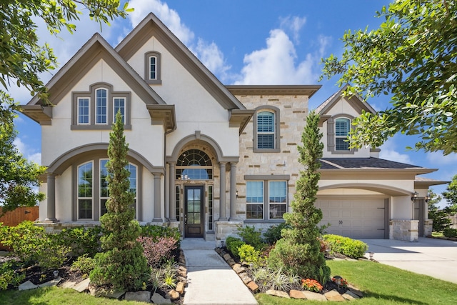27403 Laurel Bay Ct, Katy, TX 77494 - french provincial home featuring stone siding, an attached garage, stucco siding, and concrete driveway